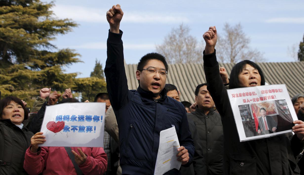 Anggota keluarga penumpang pesawat Malaysia Airlines MH370 berunjuk rasa membawa poster di Lama Temple, Beijing, Cina, (8/3). Poster Tersebut bertuliskan "Ibu akan selalu menunggu. Tidak akan menyerah." (REUTERS/Kim Kyung-hoon)