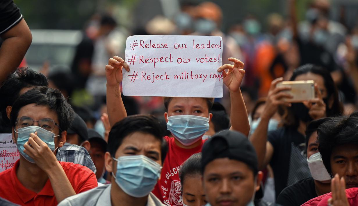 Seorang demonstran muda memegang poster saat ikut serta dalam demonstrasi menentang kudeta militer di Yangon, Myanmar pada Sabtu (6/2/2021). Ini adalah demonstrasi besar pertama sejak para jenderal merebut kekuasaan. (YE AUNG THU / AFP)