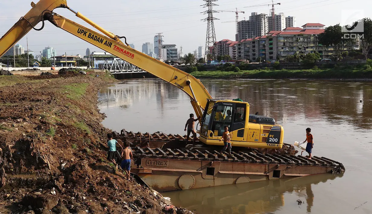 Anak-anak bermain di atas alat berat di Kanal Banjir Barat, Jakarta, Jumat (23/3). Anak-anak nekat bermain di lokasi ini meski berbahaya bagi kesehatan dan keselamatan. (Liputan6.com/Immanuel Antonius)