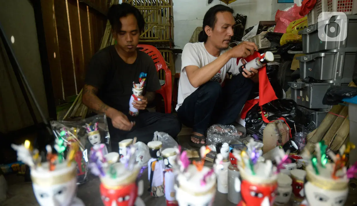 Pengrajin sedang menyelesaikan ondel-ondel hiasan yang terbuat dari limbah plastik botol di Kampung Sawah Lama, Ciputat, Tangerang Selatan, banten, Jumat (4/9/2020). Dalam satu hari perajin bisa menyelesaikan 30 biji kerajinan ondel-ondel budaya khas Betawi. (merdeka.com/Dwi Narwoko)