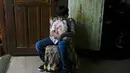 Kian Navales berpose di rumahnya sambil memegang bantal dengan foto mendiang ayahnya, Arthur, yang meninggal karena virus corona di kota Quezon, Filipina pada 6 Juli 2021. Navales, yang juga terkena COVID-19, rindu pergi makan mie bersama ayahnya.  (AP Photo/Aaron Favila)