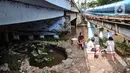 Warga bersantai di taman kolong jembatan Pegangsaan, Jakarta, Minggu (7/2/2021). Penataan taman di kolong Jembatan Pegangsaan rampung dibangun yang kini telah dilengkapi tanaman hias, kolam ikan, mural, lampu warna-warni dan area untuk interaksi warga. (merdeka.com/Iqbal S Nugroho)