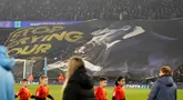 Suporter Manchester City membentangkan spanduk bergambar Rodri yang sedang mencium trofi penghargaan Ballon d'Or dan bertuliskan 'Stop Crying Your Heart Out' dalam laga leg 1 babak playoff Liga Champions 2024/2025 melawan Real Madrid di Etihad Stadium, Manchester, Inggris, Rabu (12/02/2025) WIB. (AP Photo/Dave Thompson)