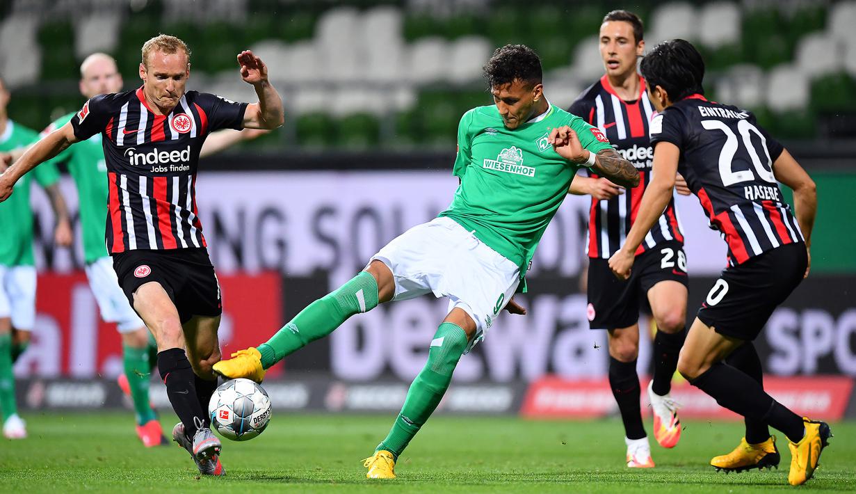 Gelandang Eintracht Frankfurt, Makoto Hasebe, berebut bola dengan pemain Werder Bremen pada laga lanjutan Bundesliga di Weser Stadion, Kamis (4/6/2020) dini hari WIB. Frankfurt menang 3-0 atas Bremen. (AFP/Stuart Franklin/pool)