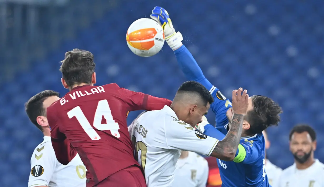 Kiper SC Braga, Tiago Sa (kanan) menepis bola hasil sundulan gelandang AS Roma, Gonzalo Villar dalam laga leg kedua babak 32 Besar Liga Europa 2020/21 di Olimpico Stadium, Kamis (25/2/2021). SC Braga kalah 1-3 dari AS Roma dan gagal lolos ke babak 16 Besar. (AFP/Alberto Pizzoli)