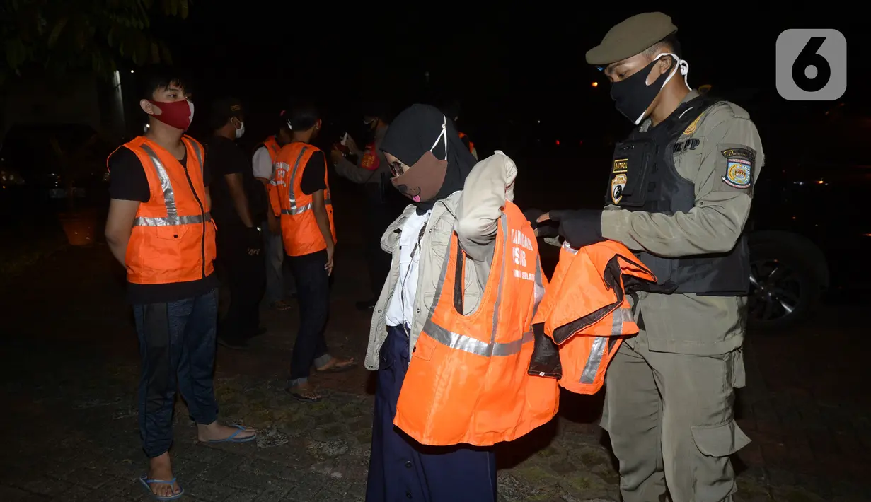 Petugas melakukan Operasi Yustisi mencegah penularan Covid-19 di Taman Perdamaian, Tangerang Selatan, Banten, Rabu (23/9/2020). Sebagai efek jera, warga yang tidak mengenakan masker diberi sanksi sosial berupa membersihkan toilet, menyapu, push up, dan denda Rp 50 ribu. (merdeka.com/Dwi Narwoko)