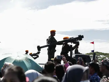 Pasukan khusus (Paskhas) TNI AU berdiri diatas mobil sambil memegang senjata saat melakukan defile pada gladi HUT TNI di Taxi Way Skuadron Udara Bandara Halim Perdanakusumah, Jakarta, Minggu (9/4). (Liputan6.com/Faizal Fanani)