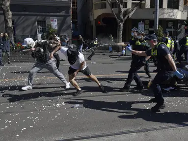 Polisi menggunakan semprotan merica pada pengunjuk rasa selama protes anti-lockdown di Melbourne, Australia, Sabtu (21/8/2021). Para pengunjuk rasa berunjuk rasa menentang pembatasan pemerintah yang ditempatkan dalam upaya mengurangi wabah COVID-19. (James Ross/AAP Image via AP)