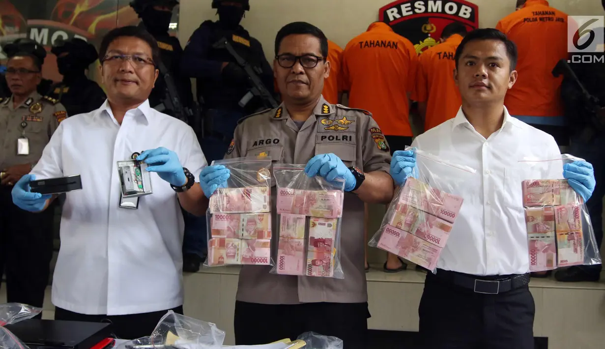 Kabid Humas Polda Metro Jaya Kombes Pol Argo Yuwono (tengah) dan Dirkrimum Polda Metro Jaya Kombes Pol Nico Afinta (kiri) menunjukkan barang bukti saat pengungkapan kasus Skimming di Polda Metro Jaya, Jakarta, Selasa (4/3). (Liputan6.com/Arya Manggala)