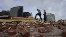 Petugas pemadam kebakaran menaksir kerusakan saat mereka melihat melalui puing-puing setelah sebuah bangunan runtuh akibat dampak Badai Ida di New Orleans, Louisiana, Senin (30/8/2021). Badai Ida ini sebagai salah satu badai paling kuat yang pernah melanda Amerika Serikat.  (AP Photo/Eric Gay)