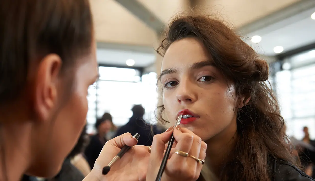 Model saat didandani di belakang panggung sebelum tampil di atas catwalk mengenakan busana Preen karya Thornton Bregazzi pada Autumn / Winter 2017 London Fashion Week di London, Inggris (19/2).  (AFP Photo / Niklas Halle'n) 