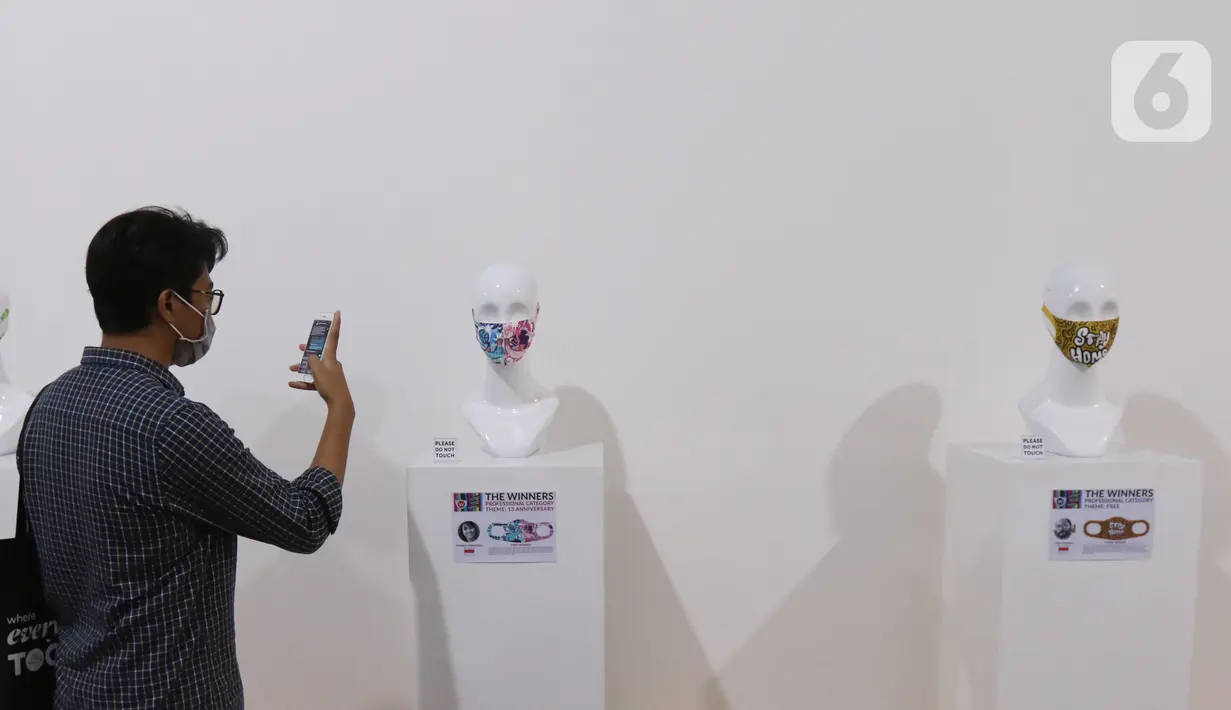 Pengunjung melihat pameran desain masker unik di Summarecon Mall Serpong, Tangerang, Minggu (1/11/2020). Pameran Face mask competition International IDC 2020 diselenggarakan untuk meningkatkan awareness masyarakat tentang pentingnya menggunakan masker di masa pandemi. (Liputan6.com/Angga Yuniar)