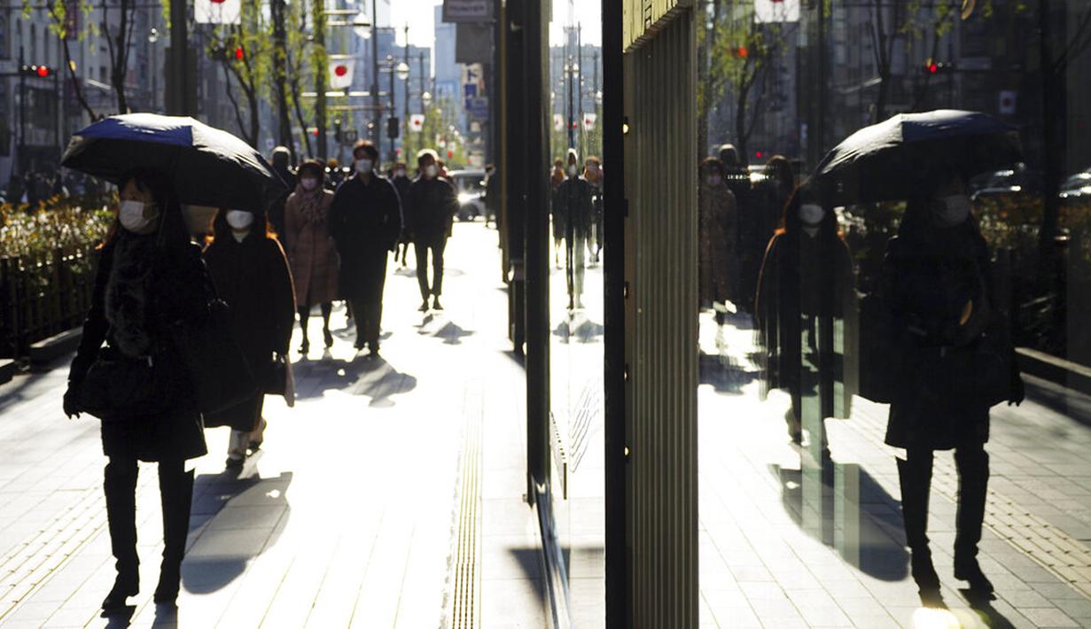 Orang-orang yang memakai masker untuk membantu mengekang penyebaran COVID-19 berjalan di sepanjang jalan perbelanjaan, Tokyo, Jepang, 29 Desember 2021. Kasus COVID-19 di Jepang meningkat lagi. (AP Photo/Eugene Hoshiko)