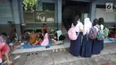 Sejumlah murid beraktivitas di Gedung SMP Negeri 26, Jalan Kebon Pala, Kampung Melayu, Jatinegara, Jakarta Timur, Selasa (6/2). Sebanyak 42 KK mengungsi di tempat tersebut. (Liputan6.com/Arya Manggala)