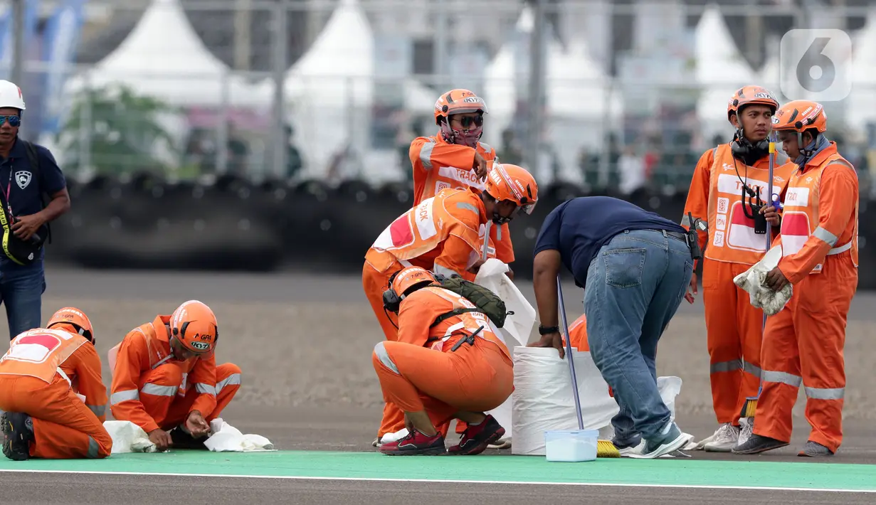 Marshal membersihkan lintasan jelang kualifikasi MotoGP di Pertamina Mandalika International Street Sirkuit, Lombok, Sabtu (19/3/2022). Pit Marshals bertugas dan berbasis di area pitlane dan mereka akan membantu ketika ada insiden di pit. (Liputan6.com/Helmi Fithriansyah)