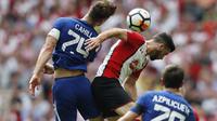 Pemain Chelsea, Gary Cahill (kiri) membuang bola dari kejaran pemain Southampton, Shane Long pada laga semifinal Piala FA di Wembley stadium, London, (22/4/2018). Chelsea menang 2-0. (AP/Frank Augstein)