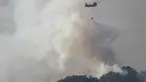 Sebuah helikopter Pasukan Bela Diri Jepang menjatuhkan air ke bagian depan kobaran api di dekat kota Otsuchi, Prefektur Iwate, Jepang pada Sabtu 25 April 2026. Hingga Ribuan petugas pemadam kebakaran masih berjuang memadamkan kebakaran hutan wilayah Otsuchi, Prefektur Iwate, Jepang. (ANDREW CABALLERO-REYNOLDS/AFP)