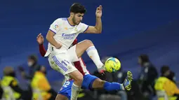 Penyerang  Real Madrid Marco Asensio berebut bola dengan bek Atletico Madrid Renan Lodi pada pekan ke-17 Liga Spanyol di Santiago Bernabeu, Senin dini hari WIB (13/12/2021). Real Madrid berhasil menaklukkan rival sekotanya Atletico Madrid dengan skor 2-0. (AP Photo/Bernat Armangue)