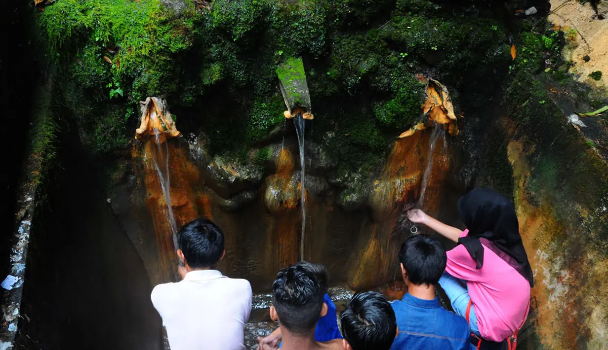 Sejumlah wisatawan memanfaatkan air yang mengalir di pancuran yang ada di objek wisata Baturraden, Purbalingga, Jawa Tengah, (31/7/2014). (Liputan6.com/Andrian M Tunay)