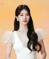 Rambut panjang bergelombangnya dibiarkan terurai lembut, dengan sebagian ditata ke atas untuk menciptakan volume yang pas.  [@skuukzky/@management_soop].