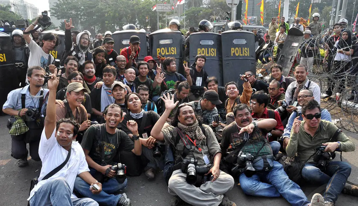 Sejumlah pewarta foto melakukan foto bersama usai demo di kawasan Patung Kuda, Jakarta, Kamis (21/8/14).(Liputan6.com/Miftahul Hayat)