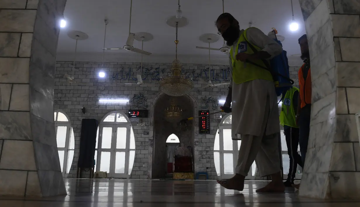 Seorang pekerja menyemprotkan disinfektan di masjid menjelang Ramadan selama penguncian nasional yang diberlakukan pemerintah sebagai tindakan pencegahan terhadap coronavirus COVID-19, di Karachi, Pakistan (21/4/2020). (AFP/Asif Hassan)