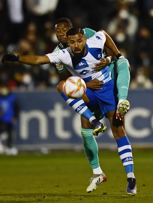 Pemain depan Alcoyano, Mourad El Ghezouani, ditantang oleh bek Real Madrid Alaba pada babak 32 besar Copa del Rey di Stadion El Callao, Alcoy, Kamis (6/1/2022) dini hari WIB. Real Madrid mengalahkan tim divis tiga Spanyol, Alcoyano dengan skor 3-1. (AP Photo/Jose Breton)