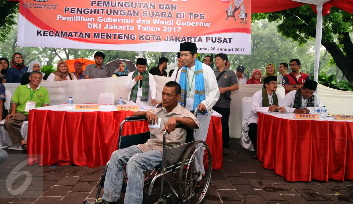 Petugas KPPS mengantar penyandang disabilitas menuju bilik suara dalam simulasi pemungutan dan penghitungan suara Pilkada DKI Jakarta di Taman Menteng, Sabtu (28/1). Simulasi ini dilaksanakan oleh KPUD Jakarta Pusat. (Liputan6.com/Helmi Fithriansyah)