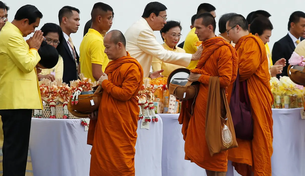 Perdana Menteri Thailand Prayuth Chan-ocha (kiri) menyapa para biksu dalam upacara di Grand Palace untuk memperingati ulang tahun ke-70 Raja Thailand Bhumibol Adulyadej berkuasa di Bangkok, Thailand (9/6). (REUTERS/Jorge Silva)