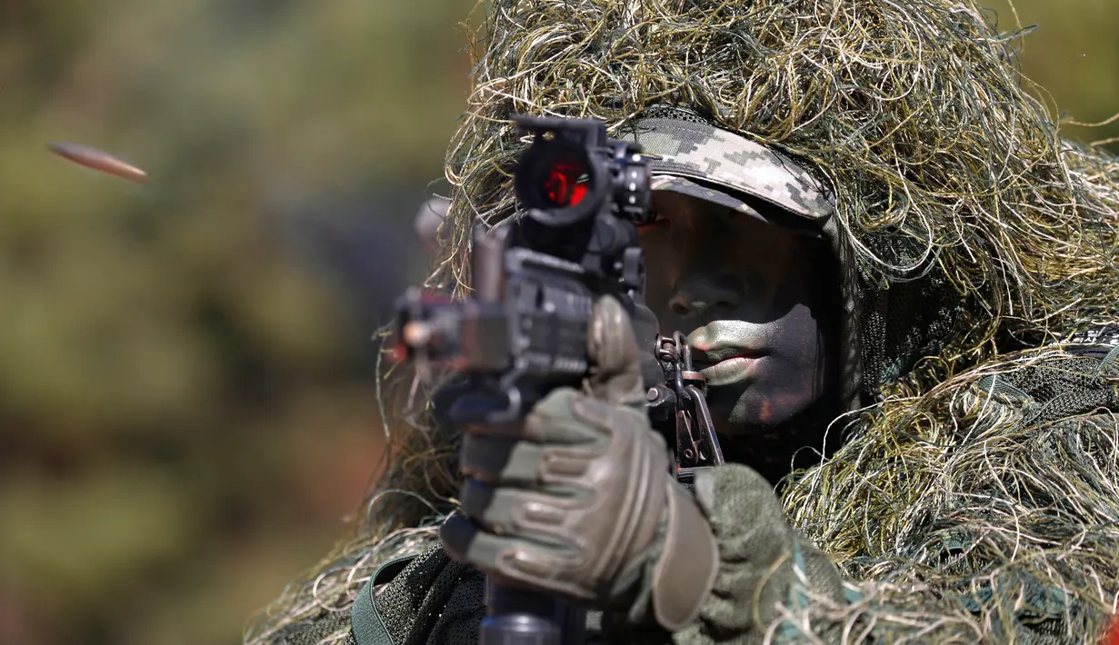 Seorang marinir beraksi selama latihan reguler di Pulau Yeonpyeong, Korea Selatan (1/11). Zona larangan terbang dan larangan latihan militer di dekat perbatasan yang dijaga ketat antara Korut dan Korsel mulai berlaku hari ini. (AP Photo/Jeon Heon-kyun)
