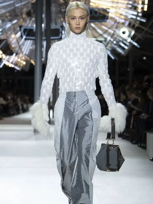 Felix mengenakan atasan turtleneck putih bertekstur, dipadukannya dengan celana ramping yang juga berwarna putih dan perak, serta sarung tangan berbulu putih. [Foto: Instagram/lixiessmoile]