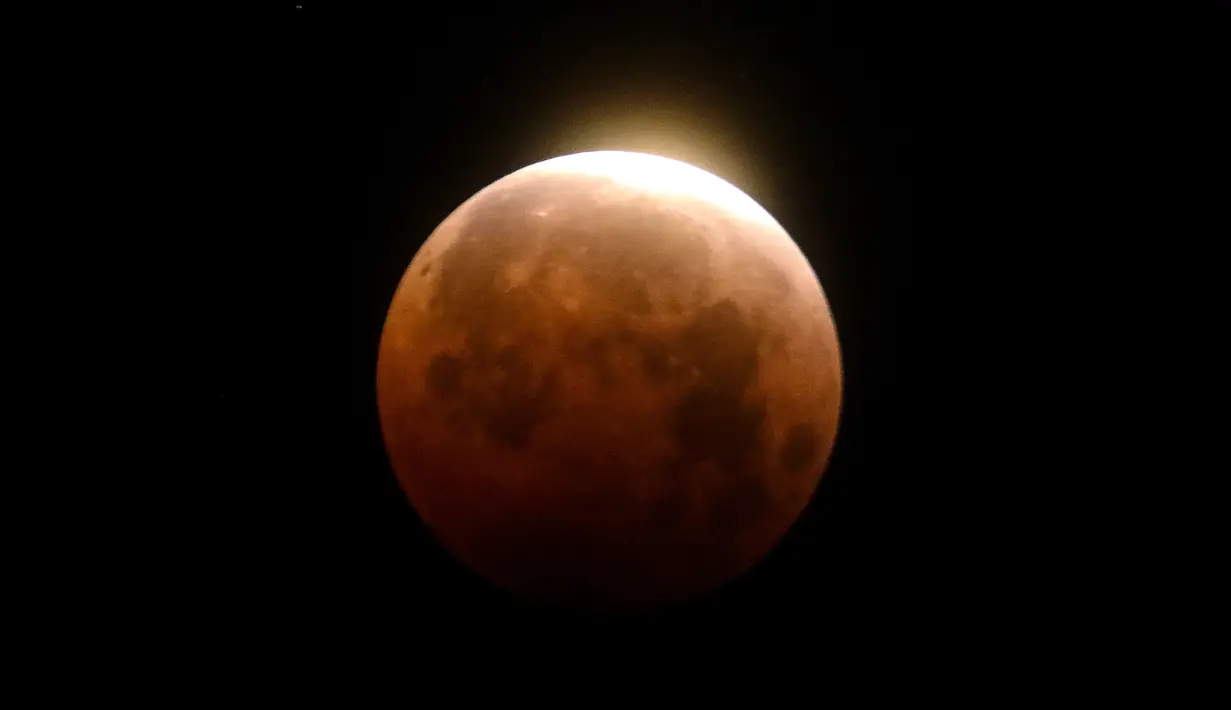 Gerhana bulan total terlihat di atas Pantai Santa Monica di Santa Monica, California, Rabu (26/5/2021). Gerhana bulan total yang bertepatan dengan Supermoon untuk pertama kalinya dalam dua tahun. (AP Photo/Ringo H.W. Chiu)