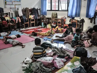 Aktivitas warga korban banjir saat mengungsi di salah satu ruang kelas SDN 01 Kampung Melayu, Jakarta, Minggu (21/2/2021). Sudah 2 hari ratusan warga dari 4 RW di Kelurahan Kampung Melayu mengungsi di gedung sekolah lantaran banjir yang tak kunjung surut. (merdeka.com/Iqbal S Nugroho)