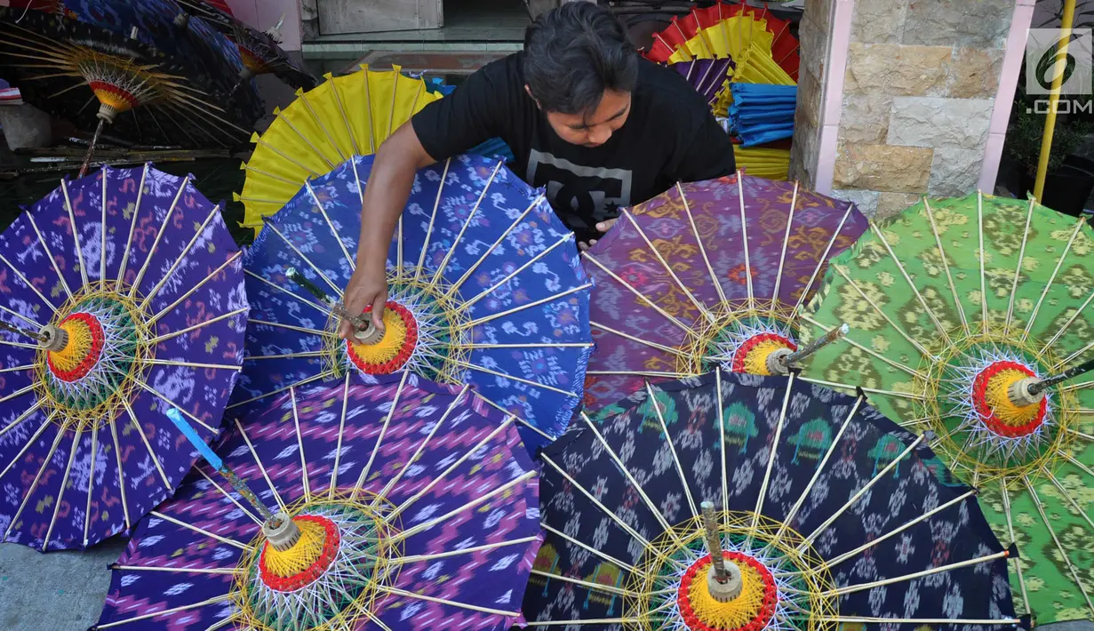 Perajin mengecek payung hias tradisional di Desa Tanjung, Kecamatan Juwiring, Klaten, Kamis (11/10). Harga per unit payung hias ini berkisar antara 50.000 hingga 3,5 juta rupiah tergantung dari ukuran. (Liputan6.com/Gholib)