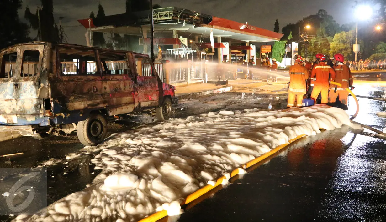 Petugas pemadam kebakaran menggunakan busa untuk memadamkan api yang membakar tangki BBM di SPBU depan Asrama Haji Pondok Gede, Jakarta, Jumat (18/12) dini hari. Tak ada korban dalam peristiwa tersebut. (Liputan6.com/Herman Zakharia)