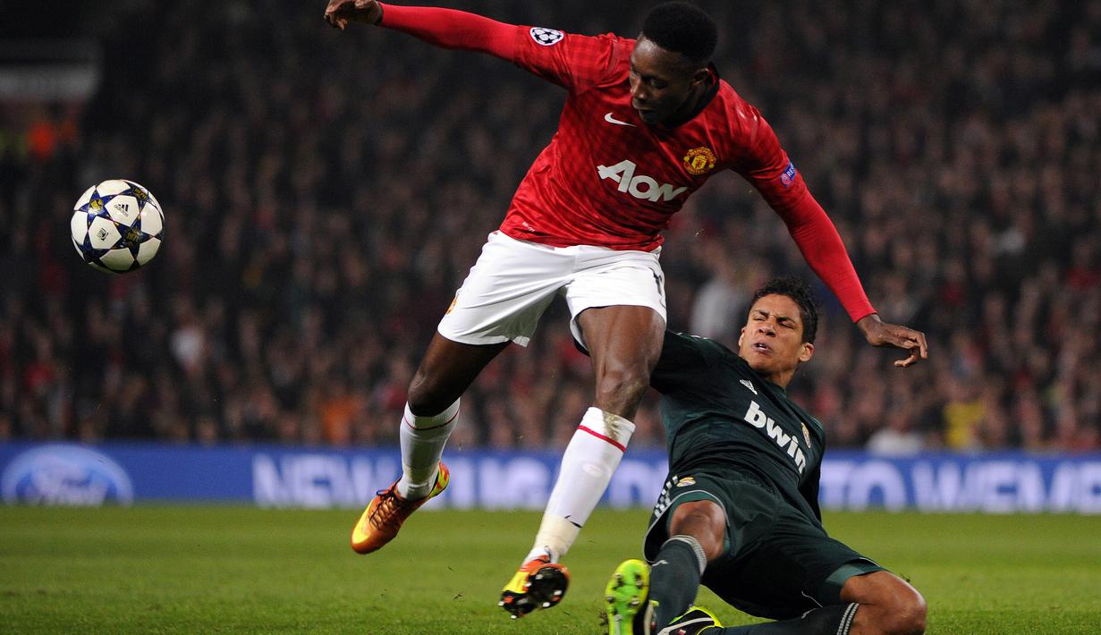 Aksi Real Raphael Varane (kanan) melakukan adangan terhadap pemain Manchester United, Danny Welbeck pada laga Liga Champions  di Old Trafford, Manchester, (5/3/2013).  (AFP/Pierre-Philippe Marcou)