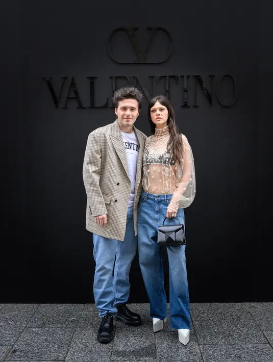 Pengantin baru Brooklyn Beckham dan Nichola Peltz juga hadir di pertunjukkan Valentino dengan busana kasual. Pasangan ini kompak dengan memadukan nuansa nude dan denim pada outfitnya. (Valentino)