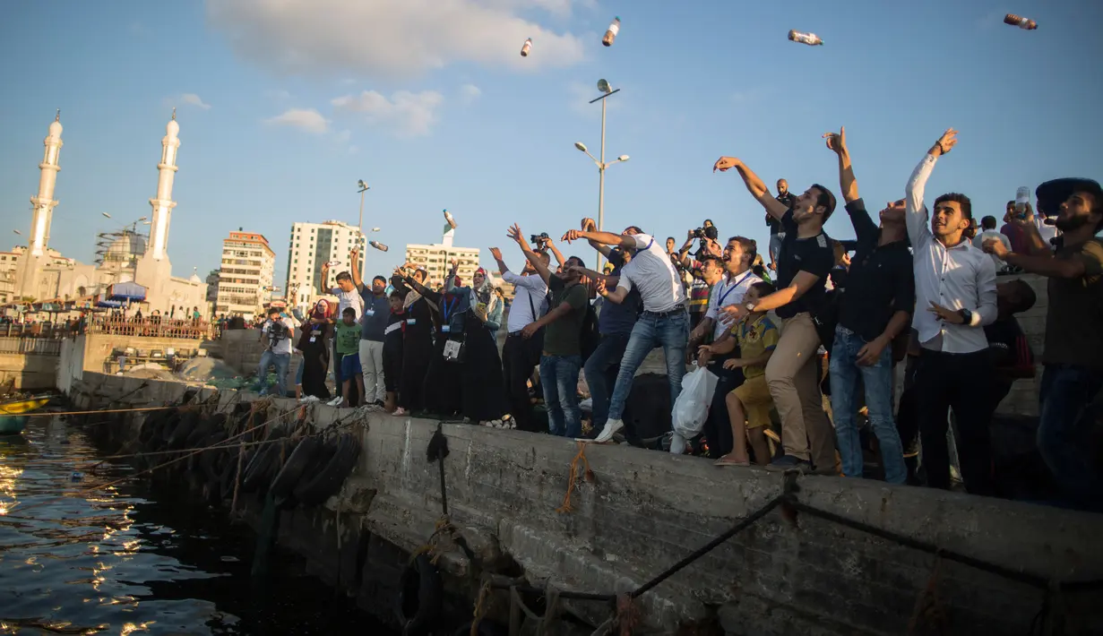 Aktivis Palestina melemparkan botol berisi pesan-pesan yang menentang pengepungan Jalur Gaza di sebuah pelabuhan Kota Gaza, Selasa (22/8). Aksi tersebut terinspirasi oleh penemuan pesan dalam botol dari pasangan Inggris di pantai Gaza. (MAHMUD HAMS/AFP)