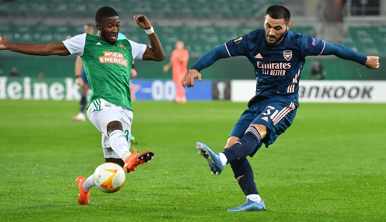 Bek Arsenal, Sead Kolasinac, berebut bola dengan penyerang Rapid Vienna, Kelvin Arase, pada laga Grup B Liga Europa 2020/2021 di Allianz Stadion, Kamis (22/10/2020) malam WIB. Arsenal menang 2-1 atas Rapid Vienna. (AFP/Joe Klamar)