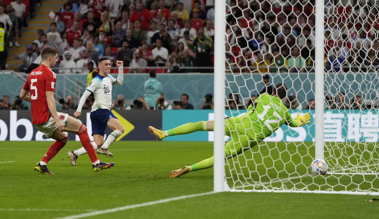 <p>Pemain Inggris, Phil Foden mencetak gol kedua timnya ke gawang Wales saat matchday ketiga Grup B Piala Dunia 2022 di Ahmad Bin Ali Stadium, Rabu (30/11/2022). (AP/Frank Augstein)</p>