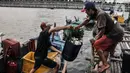 Nelayan memindahkan ikan dalam wadah di kawasan pesisir Kalibaru, Cilincing, Jakarta Utara, Senin (19/9/2022). Para nelayan di kawasan Cilincing mengeluhkan kebijakan pemerintah menaikkan harga bahan bakar minyak (BBM) bersubsidi jenis solar. (merdeka.com/Iqbal S. Nugroho)