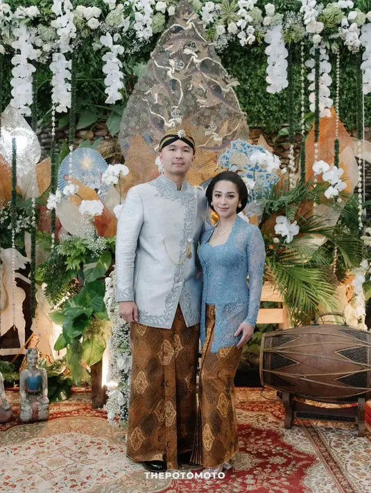 Momen tedhak siten anak Nikita Willy dan suaminya Indra. Di sini, Nikita dan Indra memilih busana adat Jawa bernuansa biru langit. Nikita tampil dengan kebaya kutubaru yang dipadu batik Sido Drajad, sedangkan Indra tampil mengenakan beskap dan batik yang serasi. [Foto: Instagram/svarna_byikatindonesia]