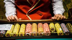 Anggota staf menyiapkan koin untuk berjudi di kasino resor MGM Cotai di Macau (13/2). MGM China membuka resor mega multi-miliar dolar baru di strip Cotai yang mewah di Macau pada tanggal 13 Februari. (AFP Photo/Anthony Wallace)