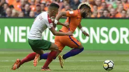 Pemain Belanda, Tonny Vilhena (kanan) melewati adangan pemain Bulgaria, Georgi Kostadinov pada laga grup A kualifikasi Piala Dunia 2018 di Amsterdam, (3/9/2017). Belanda menang 3-1. (AFP/John Thys)