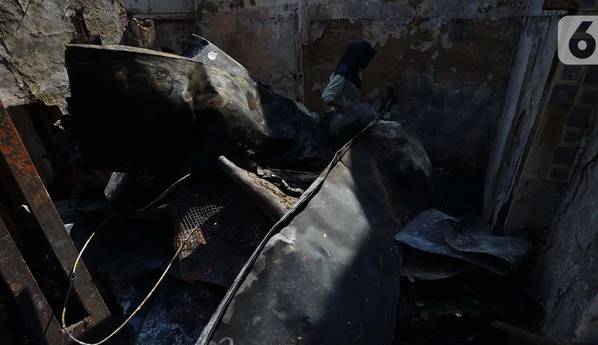 Warga membesihkan sisa barang dalam rumah yang terbakar di RW 02, Kelurahan Bidari Cina, Jakarta, Selasa (22/10/2019). Sebanyak 56 rumah di pemukiman padat penduduk tersebut hangus terbakar pada Senin, 21 Oktober 2019. (merdeka.com/Imam Buhori)