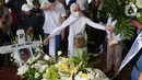 Kerabat dan keluarga meletakkan bunga di atas makam aktris senior Rima Melati di TPU Tanah Kusir, Jakarta Selatan, Sabtu (25/6/2022). Setelah prosesi pemakaman, keluarga dan kerabat meletakkan berbagai karangan bunga sebagai ucapan belasungkawa terakhir kepada Rima Melati. (Liputan6.com/Angga Yuniar)