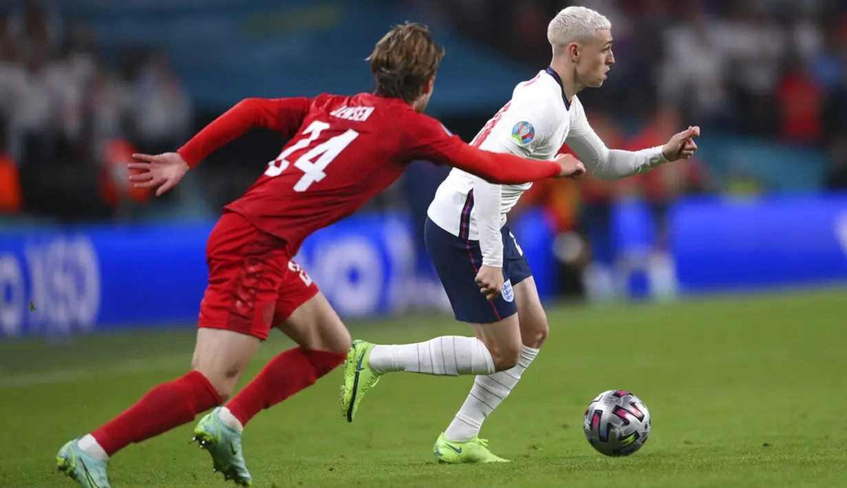 Gelandang Inggris, Phil Foden membawa bola dari kawalan pemain Denmark, Mathias Jensen pada pertandingan semifinal Euro 2020 di Stadion Wembley, London, Kamis (8/7/2021). Perjalanan terjauh Inggris di pentas Eropa sebelumnya adalah semifinal. (Laurence Griffiths/Pool Photo via AP)