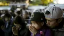 Seorang pria dan seorang anak berdoa pada hari pertama tahun baru di Shinto Kuil Meiji di Tokyo, Jepang, (1/1/2015). (REUTERS/Thomas Peter)