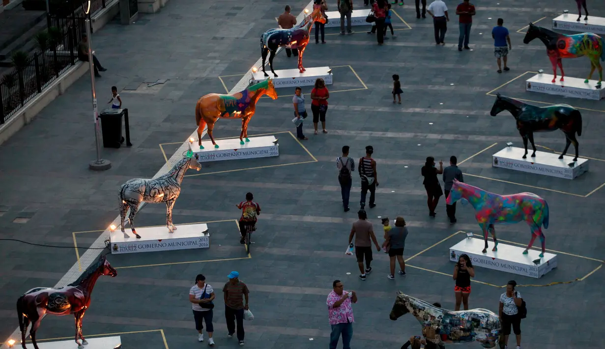 Wisatawan tampak memadati pusat kota Ciudad Juarez untuk melihat patung kuda berwarna – warni hasil seniaman setempat, MeksikoPemerintah sengaja menyediakan pameran kuda ini agar menarik wisatawan luar untuk datang ke Meksiko. (REUTERS/Jose Luis Gonzalez)