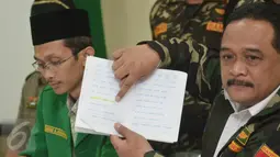 Wakil Ketum GP Ansor Benny Rhamdani menunjukkan tulisan yang berbunyi "ha ti ha ti man haj ba til" dari buku pelajaran tingkat TK yang isinya memuat unsur radikalisme saat jumpa pers di Kantor GP Ansor, Jakarta, Rabu (20/1). (Liputan6.com/Faizal Fanani)